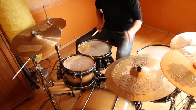 A drummer performing on his Drumset.
