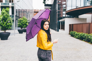 Knee figure of long straight hair woman walking outdoor in the city holding an umbrella in a rainy day -