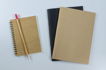 Recycled paper notebook pencils on white background