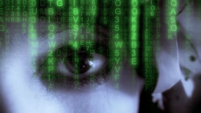 Matrix sci-fi code rain falling over a woman's eye looking in camera. Mystery, sensuality, technology. Blue and green.
