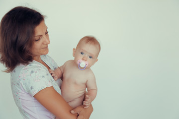 A girl holding a baby in her arms in the studio