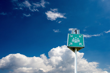 Rettungszeichen, Sammelstelle, Sammelpunkt vor blauem Himmel