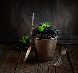 Fresh blackberries in a bucket on a wooden background. rustic style