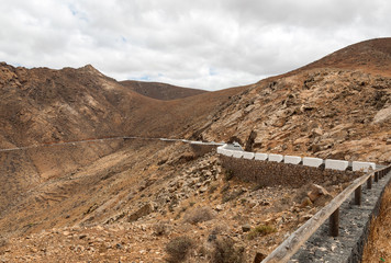 Beautiful volcanic mountains and the road on a mountain slope.  Road from la Pared to Betancuria . Fuerteventura. Canary Islands
