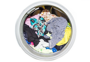 close up of  modern washing machine loaded with clothes isolated on white background.   full  dirty...