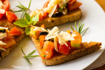 Bruschetta - Bruschetta with sliced tomatoes salad and olive with herb topping.