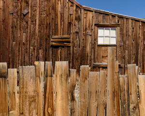 Wooden plank fence in front of wooden cabin