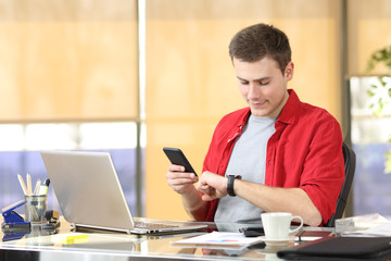Businessman using smart watch and mobile phone