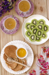Pancakes with honey and a cup of tea of coffee for breakfast  