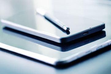 Stylus pen on a smart phone. Dark background. Technology mobile.