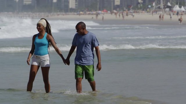 Young brazilian couple walking on the beach