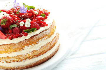 Delicious biscuit cake with berries on blue wooden table