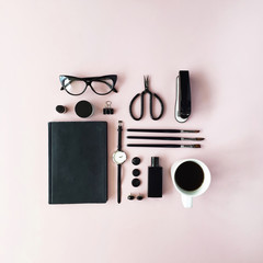 Fototapeta na wymiar Flat lay, top view black style office table desk. feminine working supplies: glasses, diary, watches, perfume, brushes, scissors, coffee on pink background.