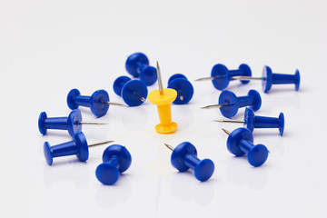 Blue and yellow thumbtacks on a white background./Blue and yellow thumbtacks on a white background.