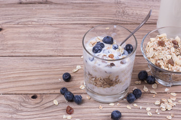Yogurt with blueberry and cereal of glass in a jar on a wooden t