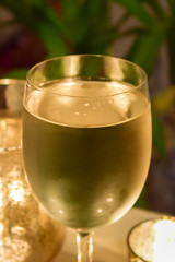 Mit Weisswein gefülltes Weinglas im Kerzenlicht