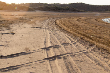 road in the sand on the lake