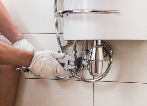 Closeup Man Fixing Sink In A Bathroom