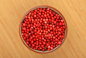 Lingonberry (Vaccinium vitis-idaea) in dish on wooden background