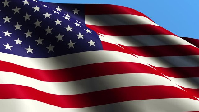 A large flag of the United States of America is waving in the breeze on a bright sunny day against the background of a cloudless blue sky. 3840x2160 4K video.