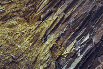 Closeup of tectonic basalt rock layers surface. Rock backgrounds and textures.