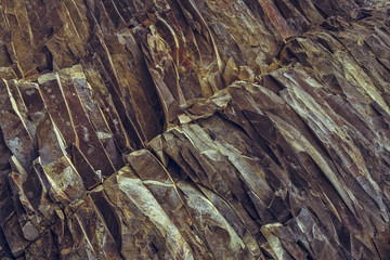 Ferric rock layers detail in a basalt quarry. Rusty rock layers background.