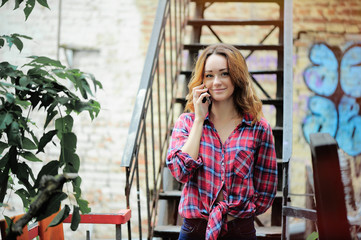 bright girl in  plaid shirt talking on the phone