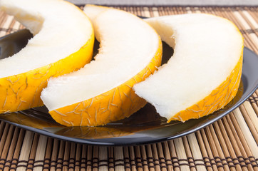 Three slices of juicy yellow melon closeup