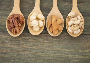 Group of nuts on wooden table. Almonds, pistachios, macadamia and pecan nut