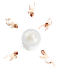 Cute babies crawling to big feeding bottle with milk on white background