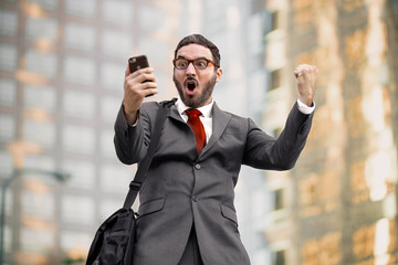 Ecstatic happy executive sales businessman cheering excited in celebration after good news - 119488514