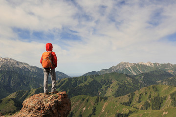 successful woman hiker hiking at beautiful mountain peak