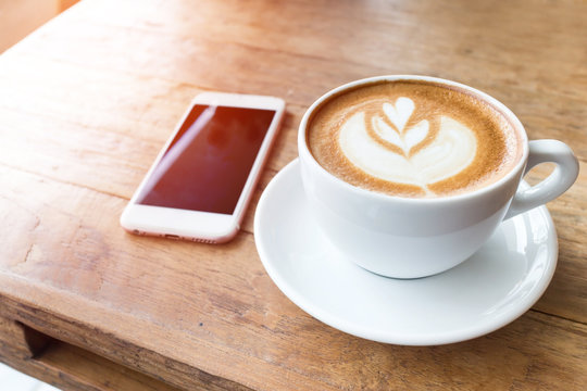 Coffee cup and mobile phone on wood table background, fillter ef