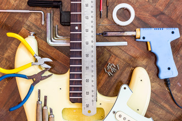 yellow electric guitar on wood in repair & luthier workshop, fixing & musical instrument repairing concept - obrazy, fototapety, plakaty