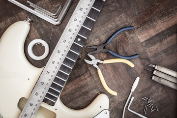 Obraz premium yellow electric guitar on wood in repair & luthier workshop, fixing & musical instrument repairing concept