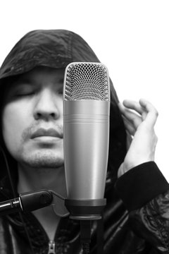 emotion portrait of asian handsome male vocal singing with condenser microphone in music recording studio, bw filter