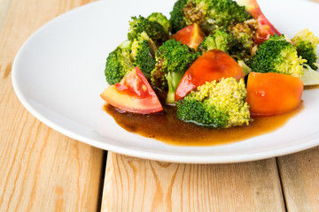 Plate with cherry tomatoes and broccoli stir-fry. in plate on ta