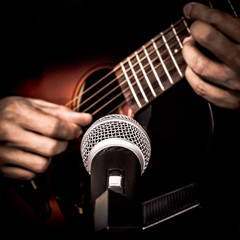 musician hands playing & recording acoustic guitar