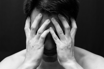 Fototapeta premium asian handsome man in black and white emotion portrait photo. feel sad, headache, alone on dark background