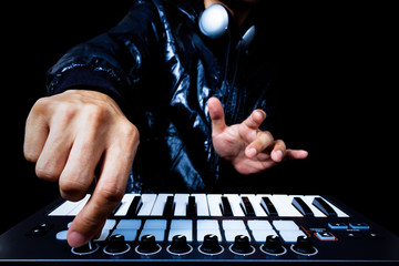 professional musician or DJ hand on studio keyboard synthesizer, isolated on black & art filter for...
