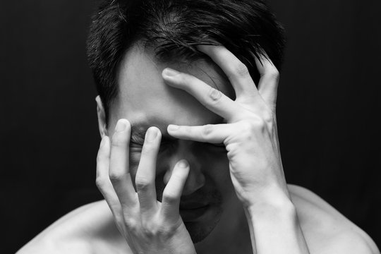 asian handsome man in black and white emotion portrait photo / feel sad ,headache and alone on dark background
