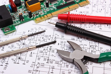 Printed circuit board. precision tools and cable of multimeter on diagram of electronics