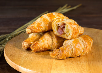 Ham and cheese croissant on cutting board