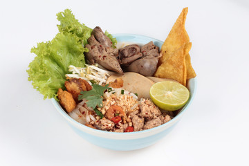 Noodle with tom yam topped with minced pork,chicken liver,wonton,shrimp ,chili. and green lemon on white background.