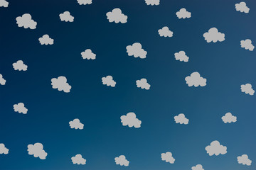 Hand drawn grey clouds pattern on dark blue sky 