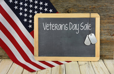 Veterans Day Sale on black chalkboard with military dog tags and American flag