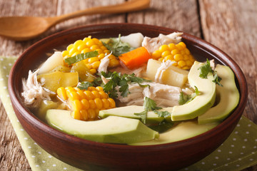 Tasty soup ajiaco with chicken and vegetables close up. horizontal
