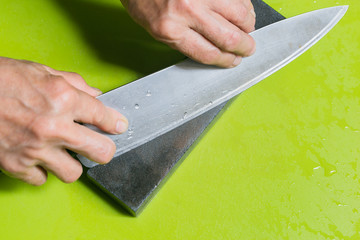 hand sharpening chopper with grindstone in the kitchen, kitchen knife.