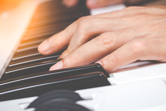 hands playing on piano keys for music background