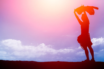 Silhouette of Man Raising His Hands against the wind and sun shade, freedom man concept.